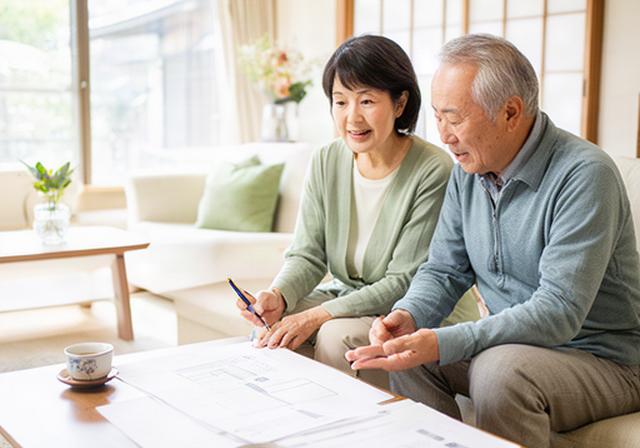 佐賀の明るいリビングで老後の家計表を見ながら話す夫婦